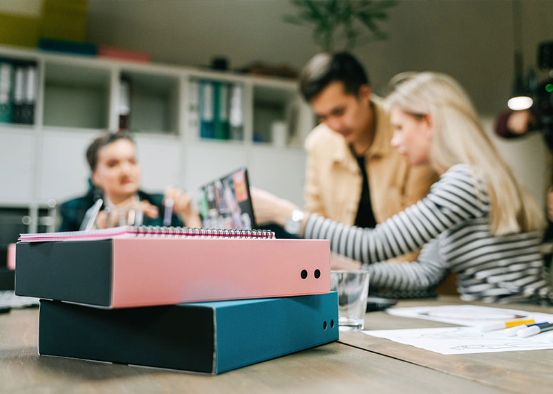 Foto: Zwei Männer und eine Frau an einem Tisch im Gespräch
