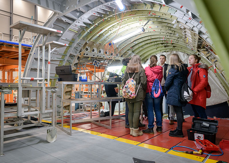 Foto: Einige Personen betrachten das Innere eines Flugzeugs in Bau.