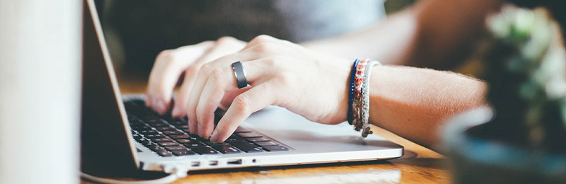 Foto: Hände tippen auf einem Laptop.