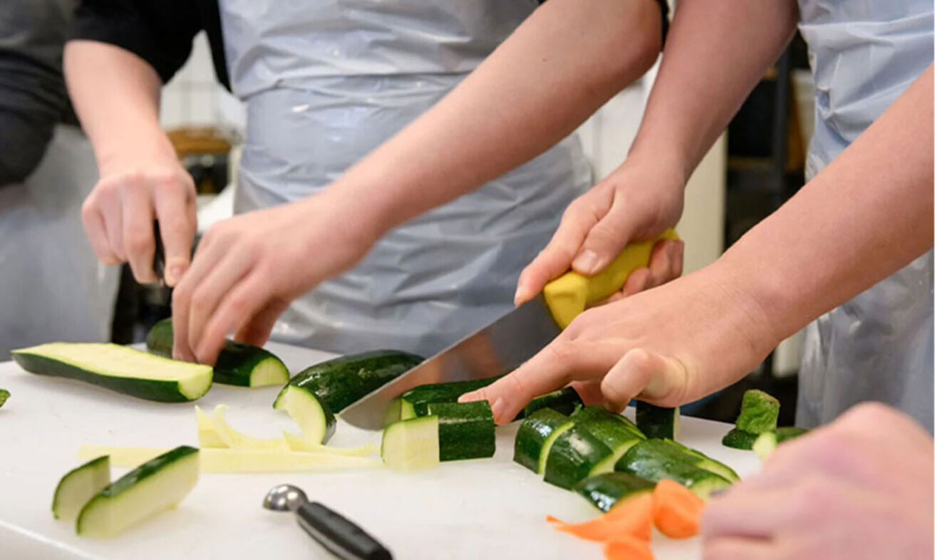 Foto: Hände schneiden Gemüse.