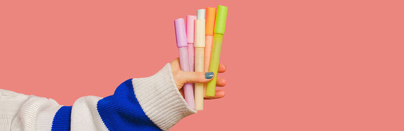 Eine Hand hat Stifte in der Hand.