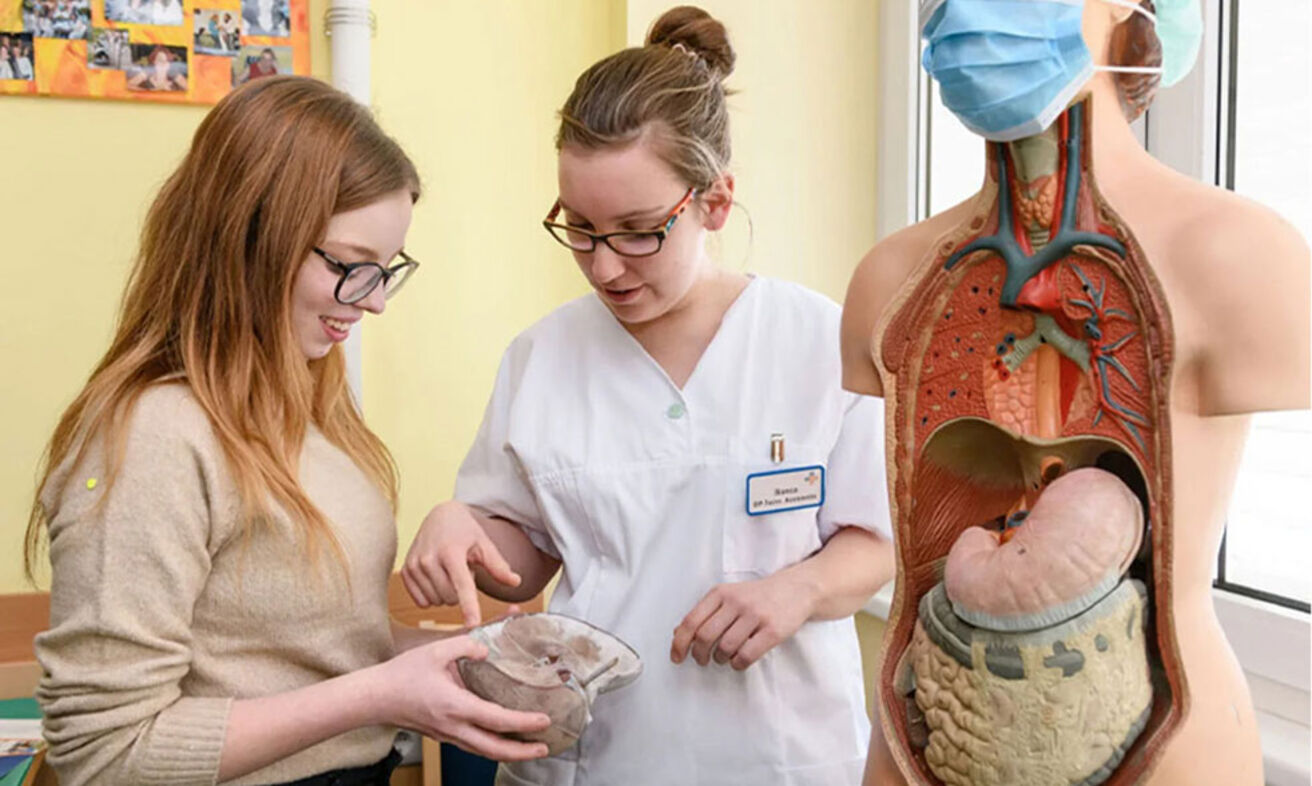 Foto: Eine Ärztin erklärt einer Schülerin ein menschliches Organ.
